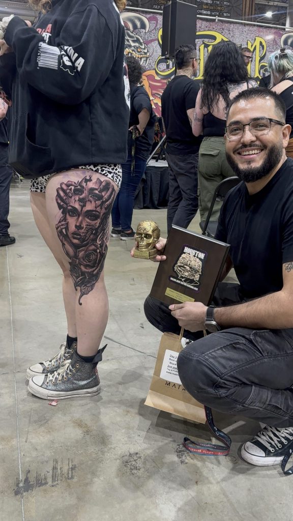 Happy Tattoo Artist displays award