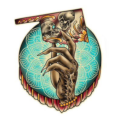 Villain Arts Oklahoma City logo of a clawed, tattooed hand holding a card with two kissing skulls, set over a teal mandala circle with a red draped border.