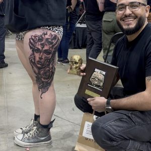 Happy Tattoo Artist displays award